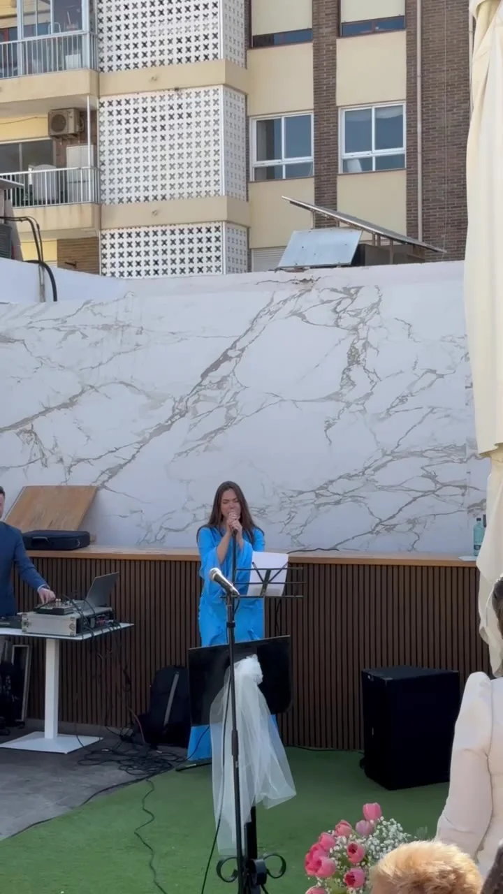 Rocío cantando en una boda civil en una terraza, con la novia de espaldas